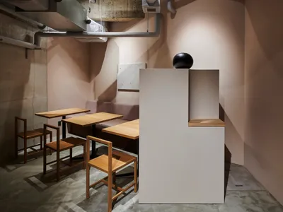 極簡風格的餐廳室內，搭配木質家具與混凝土牆面。