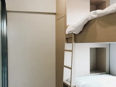 A minimalist bedroom featuring a wooden bunk bed.