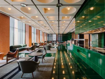Modern hotel lobby with green-tile flooring and contemporary furniture.