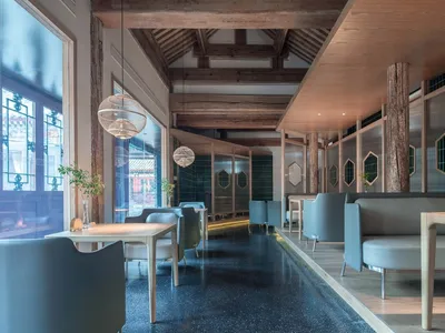 Contemporary seating and tables in a restaurant with modern design elements, including mixed materials and geometric shapes.