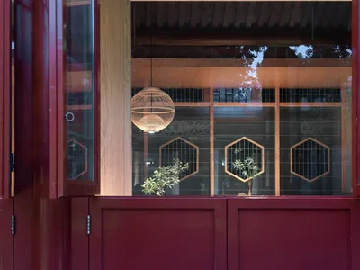 Modern restaurant interior with wooden panels and glass walls