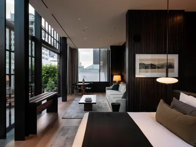 Modern hotel room with black metal accents, glass windows, and minimalist decor.
