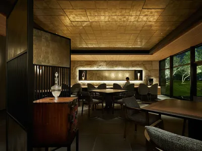 現代餐廳室內，搭配木質餐桌、石材點綴與金屬裝飾。