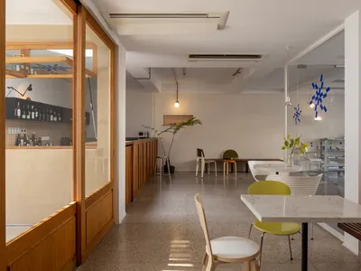 Modern restaurant interior with concrete flooring and minimalist furniture.