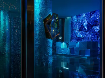 A minimalist hotel lobby featuring glass walls and geometric designs.