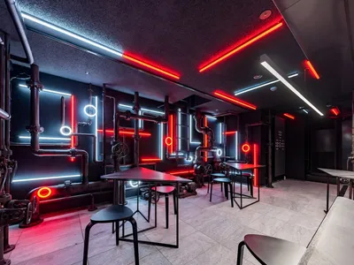Industrial-style restaurant interior with metal pipes and neon lighting