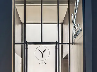 Modern hotel entrance with a glass door and metallic frame.