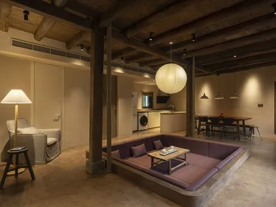 Industrial-style living room featuring a large sofa with wooden legs and a wooden floor.