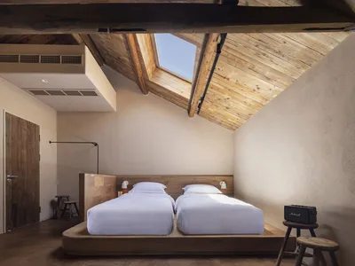 A minimalist bedroom featuring wooden furniture and a skylight.