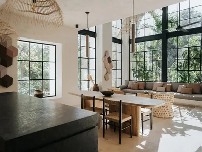 Modern minimalist living room featuring a large sofa, a wooden dining table, and hexagonal wall art.