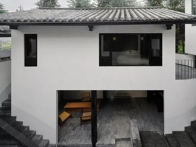 一間擁有石材牆面與地板的現代臥室，搭配簡約白色床架與木質家具。