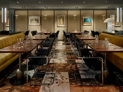 A modern restaurant interior featuring marble flooring and contemporary furniture.