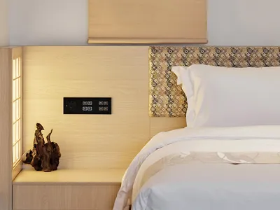 A minimalist bedroom with a wooden headboard, white bedding, and a framed painting above the bed.