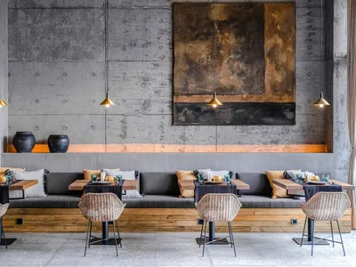 Industrial-themed restaurant interior with concrete walls and seating.