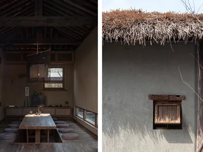 A rustic living room with wooden furniture, a thatched roof, and concrete walls.