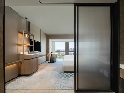 A modern hotel suite featuring marble and glass materials.