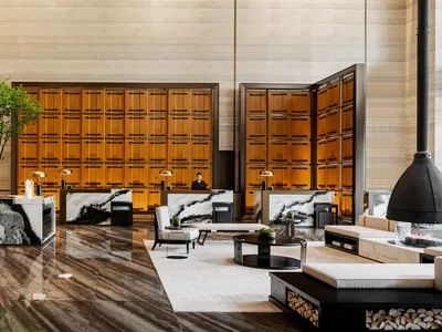 A modern hotel lobby featuring marble and concrete finishes.