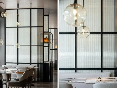 Modern restaurant with a glass wall and white seating.
