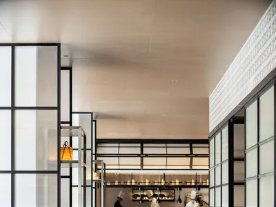 Modern restaurant interior with contemporary design featuring white chairs and tables.
