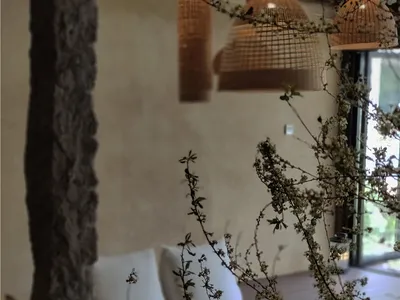 Living room with wooden furniture, cushions, and floral decor.
