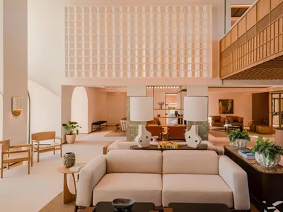 Modern and minimalist hotel lobby featuring neutral color tones and contemporary furniture.