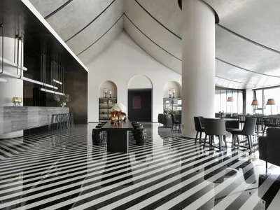 A modern restaurant with a concrete floor featuring geometric patterns.