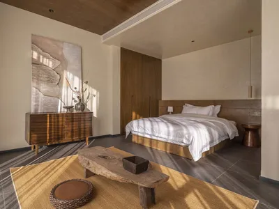 Modern minimalist bedroom featuring wooden furniture and a neutral color palette.
