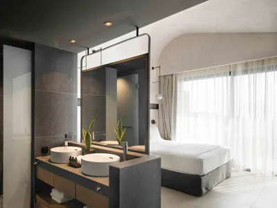 Modern bathroom with concrete and wooden elements, featuring a double sink vanity and a large mirror.