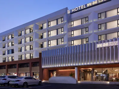 A modern hotel building with glass and concrete facade.