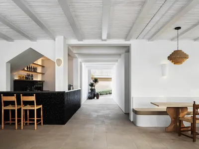 A minimalist restaurant interior featuring contemporary design elements such as wood and concrete materials.