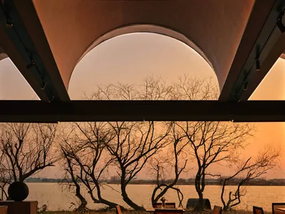 Interior view of a modern restaurant featuring wood architecture and a scenic water view