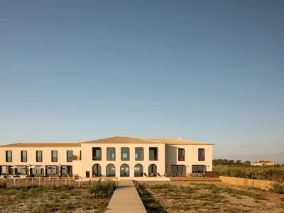 A modern style exterior of a hotel building made of sandstone material.