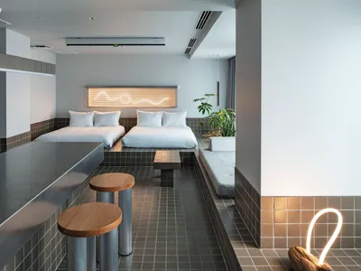 A modern hotel suite featuring wood and concrete materials.