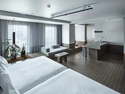 Modern hotel room with concrete tiles, plants, and minimalist design