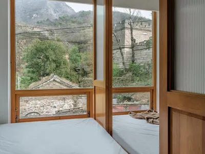 現代臥室搭配木質元素，透過大窗可眺望山景。