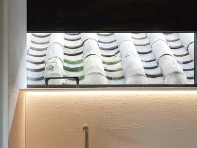 簡約住宅廚房，配備白色檯面、金屬水槽與紋理背板。
