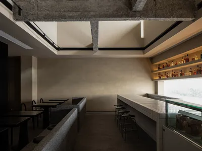 Industrial-style restaurant bar with concrete beams and brick accents.