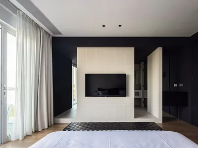 White tiled bedroom floor with minimalist decor and a television