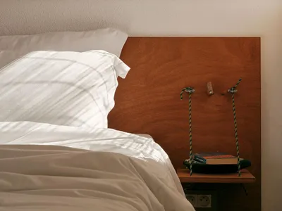 A minimalist bedroom with a wooden headboard.