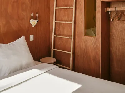 Modern minimalist bedroom with wooden walls and built-in storage solutions.