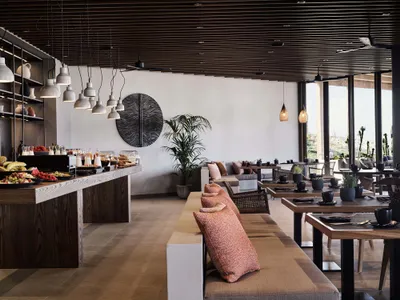 Modern restaurant interior with wooden furniture, metal accents, and ceramic elements.