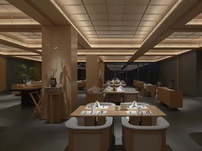 A modern restaurant interior with wooden tables and chairs, white linens, and ambient lighting.