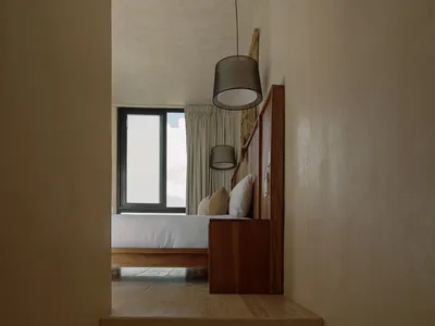 現代臥室，設有混凝土牆與木質床架。