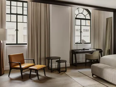 A modern bedroom featuring leather furniture, minimalistic design, and large windows.
