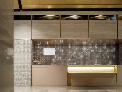 Modern interior of a hotel reception featuring wood and terrazzo materials.