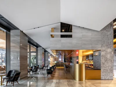 A modern restaurant bar with concrete walls and a bar counter.