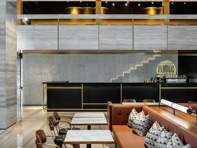 Modern restaurant interior with concrete, glass, and metal elements.