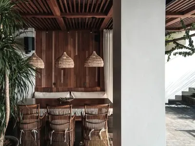 Industrial-style restaurant with wooden furniture and pendant lights.