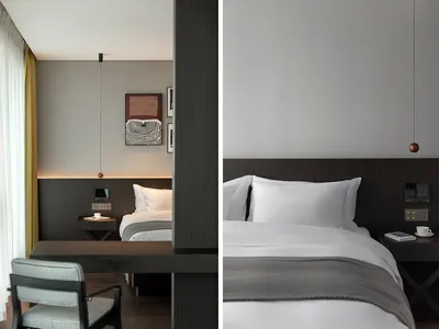 A modern bedroom featuring a luxury white bed with dark wood accents and a minimalist design.