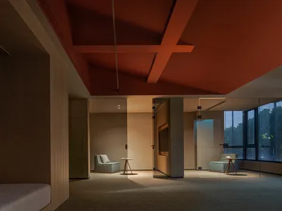 Modern hotel suite with glass walls and wooden furniture